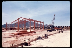In the background of this photograph members of the C Co of the 84th En Bn can be seen erecting structural steel for a warehouse in the Qui Nhon depot. In the foreground indigenous laborers are making preparations for the placement of concrete for footers of another warehouse.