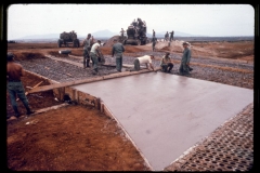 In this photograph members of A Co of the 299th En Bn are paving a concrete ramp leading to the new aircraft maintenance apron being constructed at Pleiku.